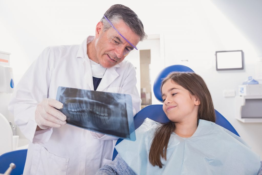 Pediatric orthodontist explains x-ray to young orthodontic patient