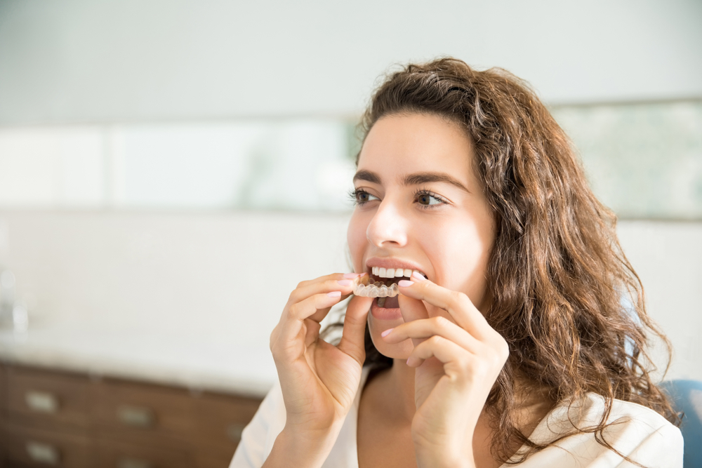 Young woman replaces her clear retainer following braces